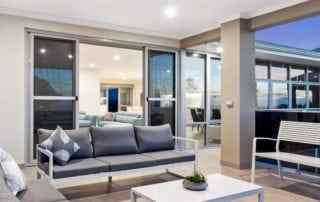 View from outdoor patio into the living room of a Perth home with stacker doors.