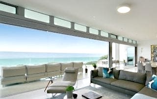 Modern Perth home using bifold doors to open living room and outdoor lounge area.