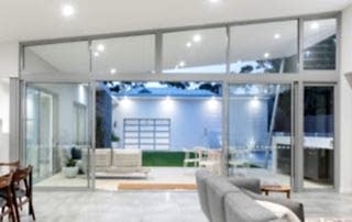 Light grey sliding doors opening up into the lounge and pool area from the living room of a Perth home.