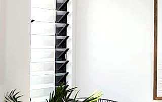 Black aluminium Louvre window installed in a modern lounge area of modern Perth home